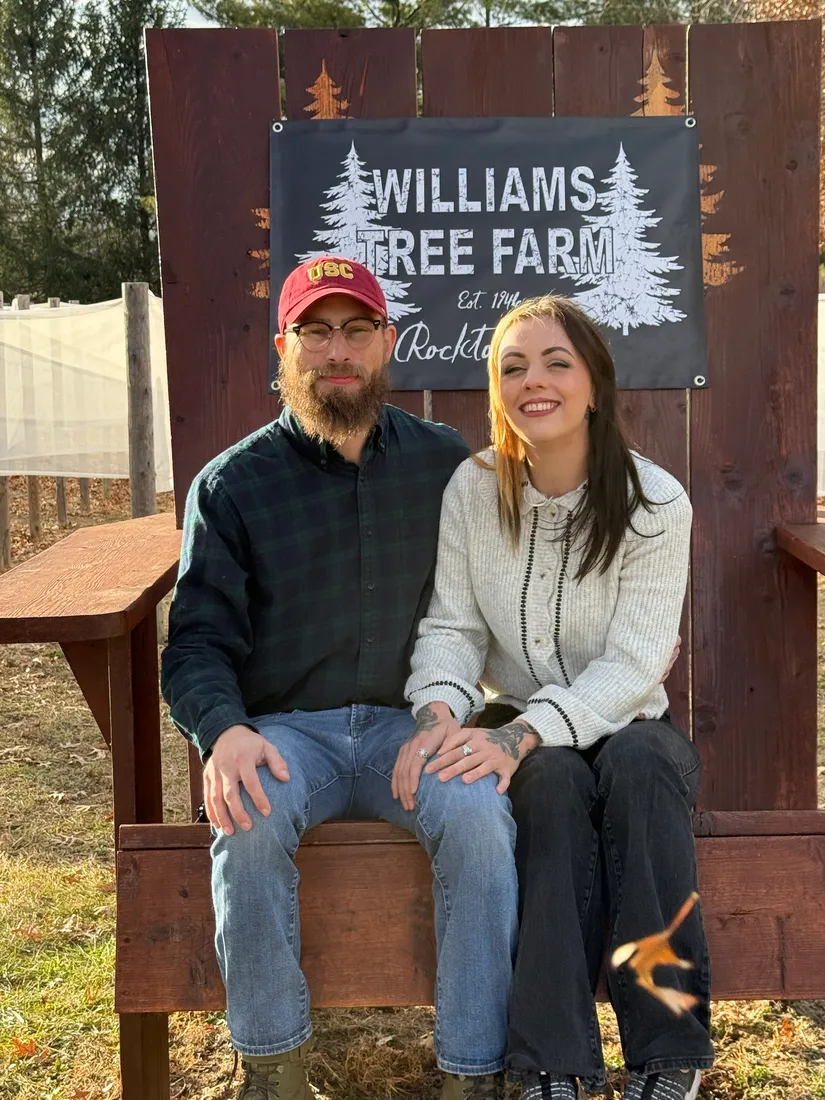 Joshua Herrington and his partner Holly on a bench at a tree farm