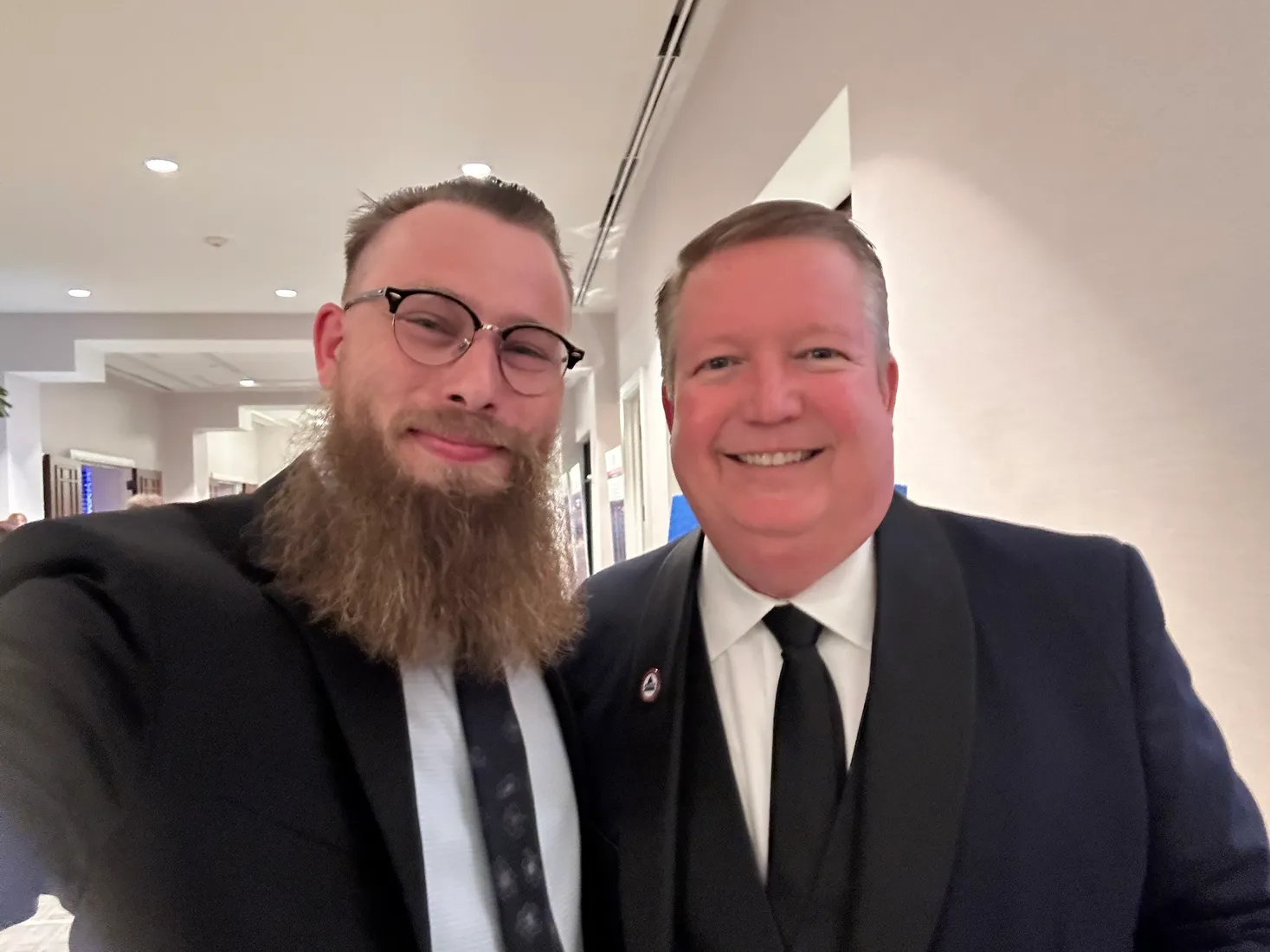 Joshua Herrington in black tie with a colleague at an evening event